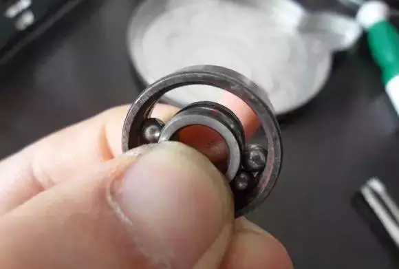 用手將軸承拿起，需要注意要向有滾珠的方向頂住